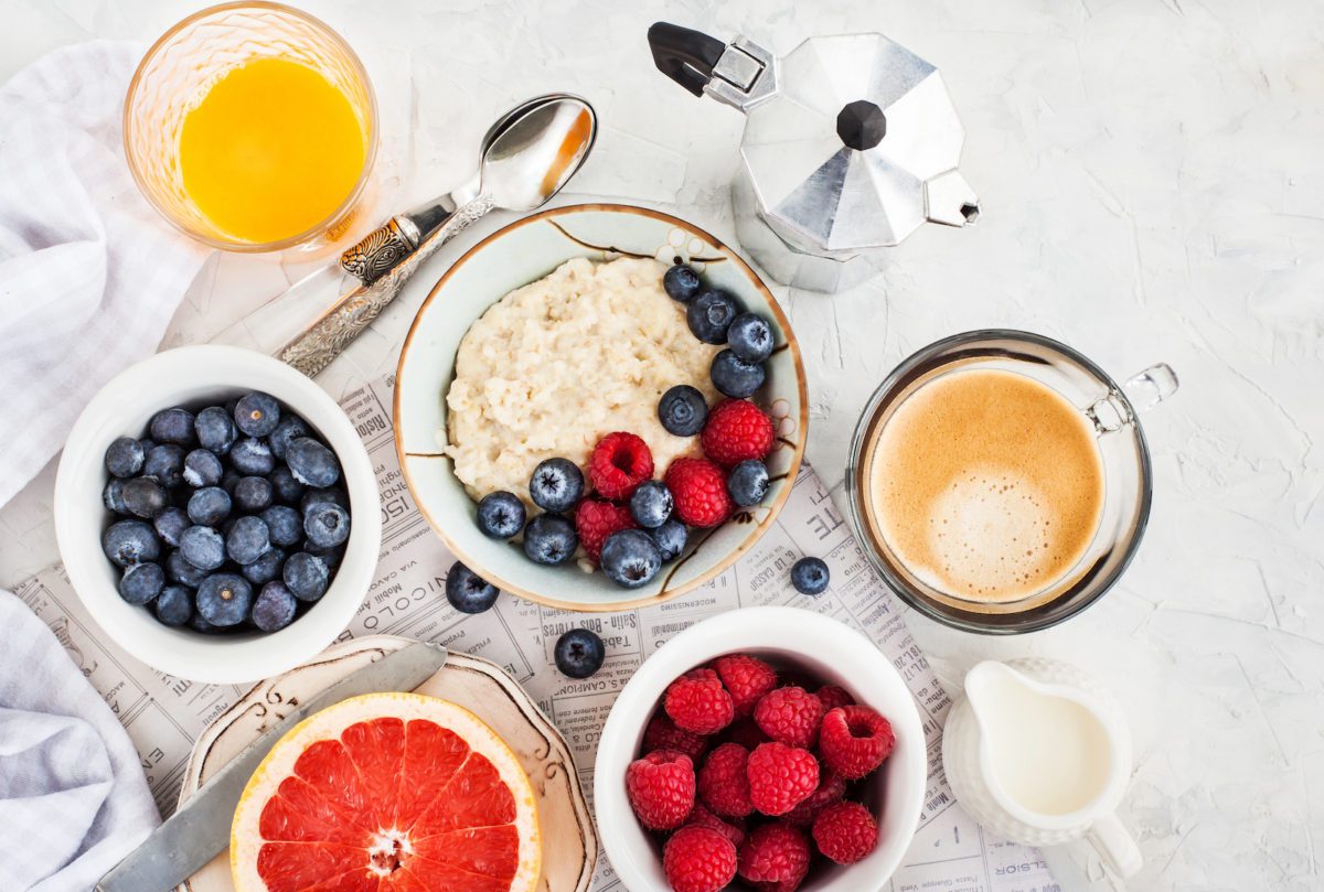 Porridge mit beeren am frühstückstisch mit kaffee